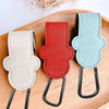 Three colored PU leather stroller organizer hooks in beige, red, and light blue displayed on a wooden board.