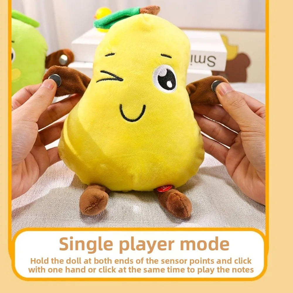 A yellow fruit plush toy is being held by hands, demonstrating a single player mode where the doll is clicked to play notes.