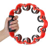 A hand is holding a red petal-shaped tambourine with an ergonomic grip.