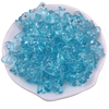 A pile of small, translucent blue acrylic bow beads for jewelry making.