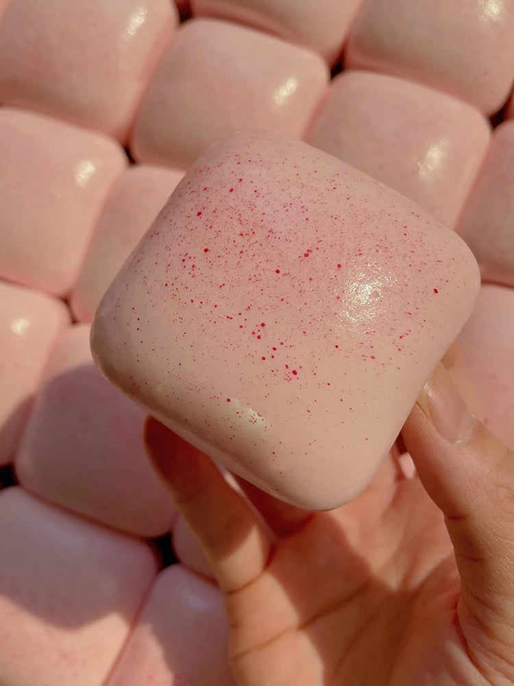 Pinkes, weiches Brot-Fidget-Spielzeug, das die Textur und den gesprenkelten Glanz zeigt.