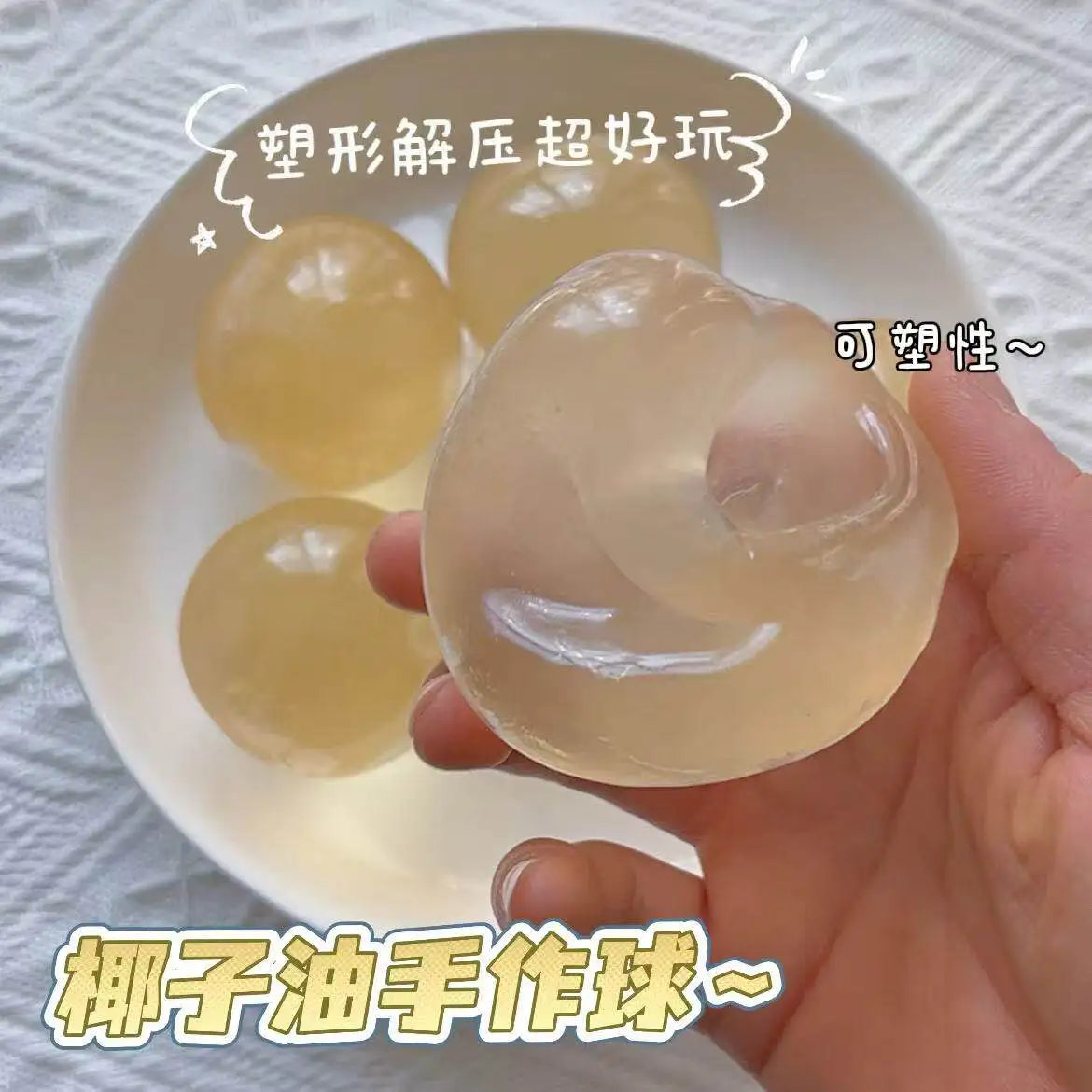 A hand holds a translucent yellow squeeze ball made from coconut oil, used for stress relief.