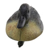 A lifelike floating duck decoy with a dark head and yellowish body, shown from above.