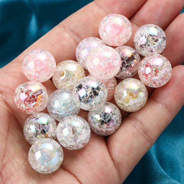 A hand holds a cluster of pink and iridescent glitter resin spacer beads for DIY jewelry making