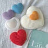 A collection of silicone heart molds in various colors including blue, purple, orange, and white resting on a white cloth.