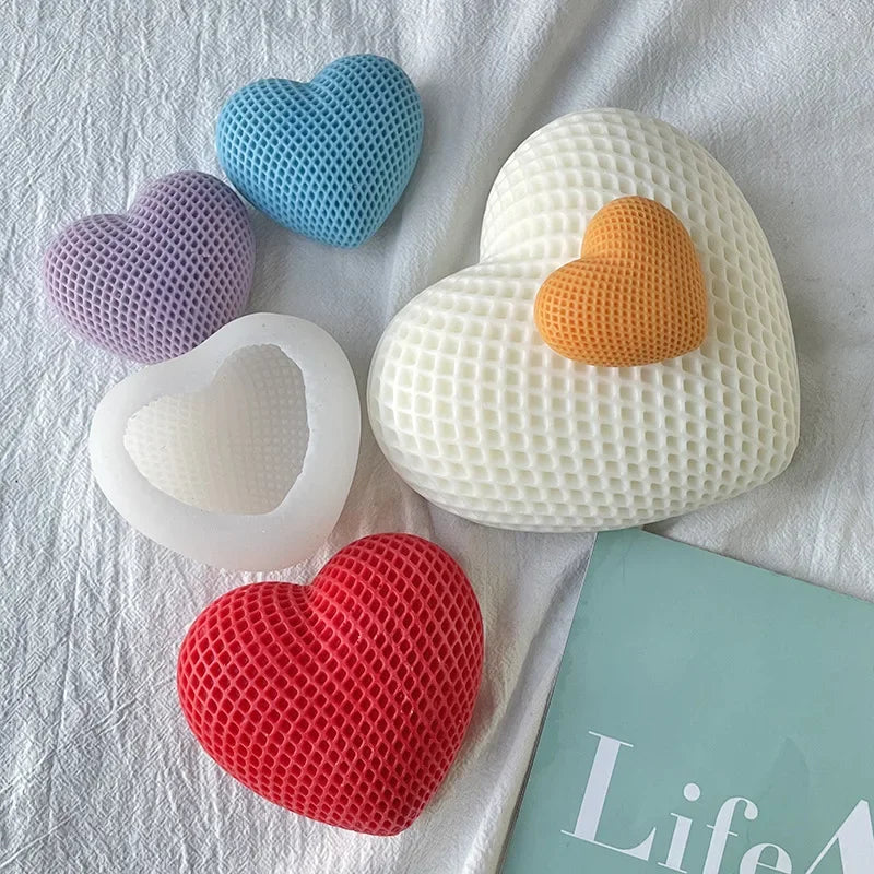 A collection of silicone heart molds in various colors including blue, purple, orange, and white resting on a white cloth.