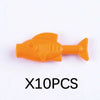 An orange plastic shark building block is shown against a white background.
