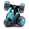A black and teal stunt car with large wheels is shown against a white background.