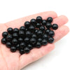 A handful of small, round, black natural stone beads for jewelry making