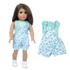 A doll wearing a light blue floral outfit consisting of overalls, a blouse, and tights.