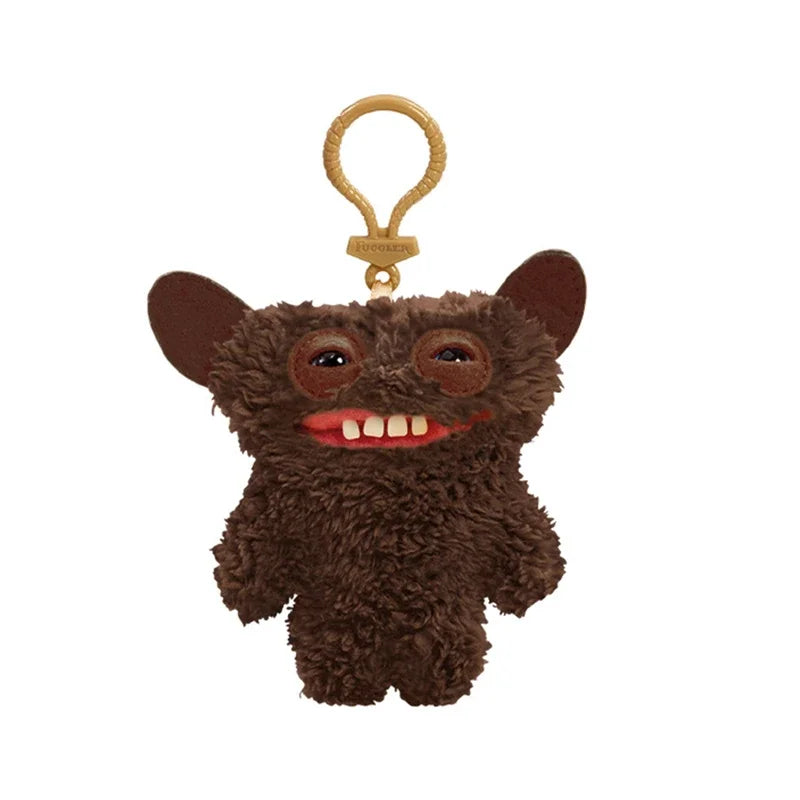 A brown, fuzzy plush monster with large eyes and teeth, attached to a gold-colored keychain.
