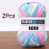 A skein of multi-colored soft chunky yarn, featuring stripes of pink, blue, and yellow, packaged for crochet and knitting.