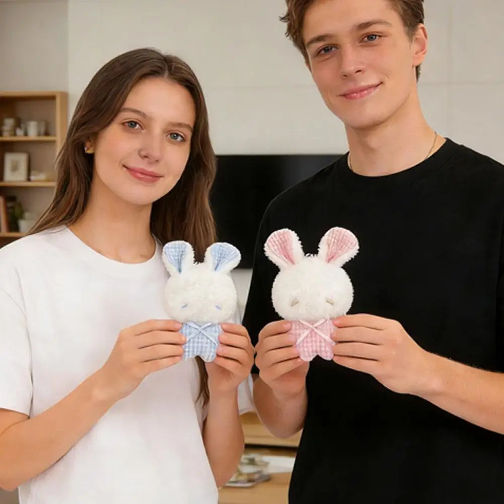 A young woman and a young man are holding adorable plush bunny keychains with movable ears.