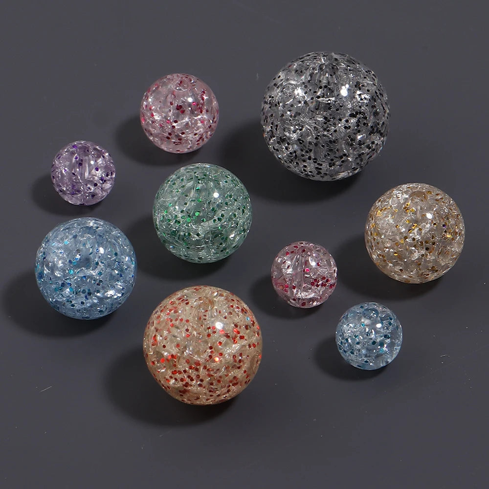 A collection of round loose spacer beads in various colors and glitter finishes, including pink, purple, blue, green, and gol