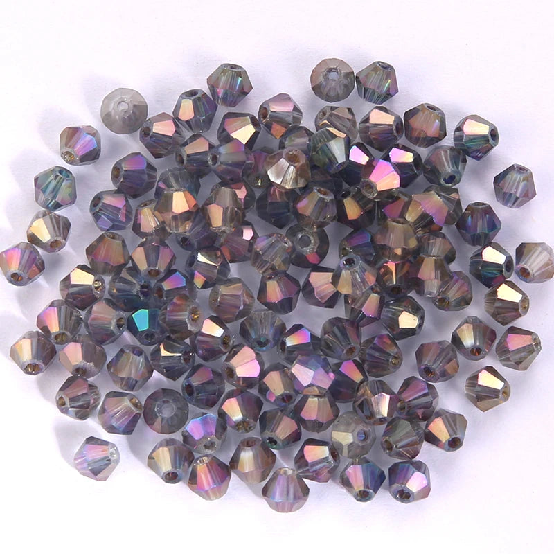 A pile of small, faceted crystal bicone glass beads in various shades of purple and blue.
