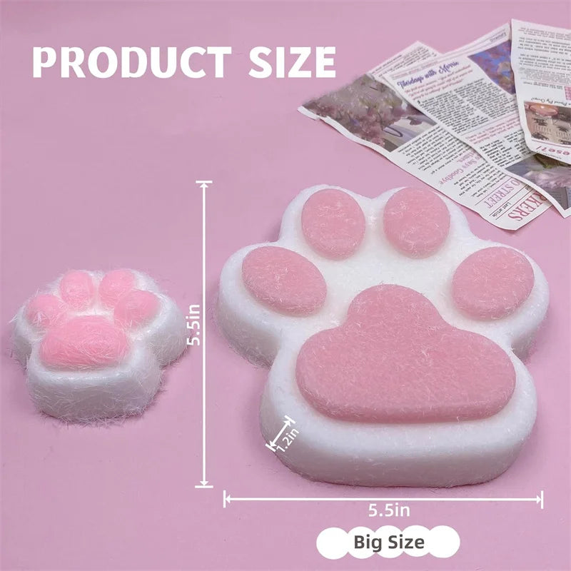 A pink squishy toy shaped like a cat paw, shown next to a printed size guide.