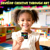 A smiling young girl holds up a piece of colorful scratch art paper for kids DIY craft.
