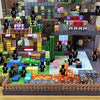 A detailed magnetic building tile set depicting a multi-level fantasy landscape with various structures and figures.