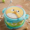 A bright blue owl double-sided musical drum for kids with yellow and white features resting on a wooden floor.