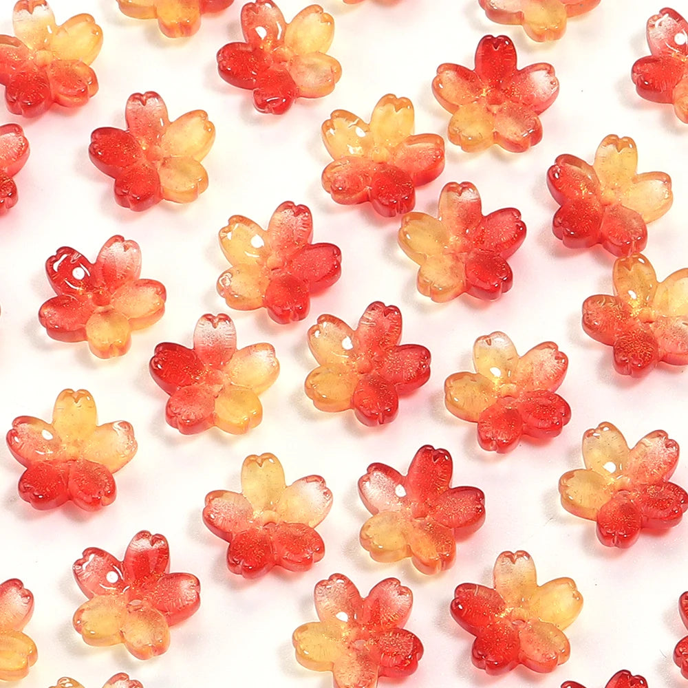A set of 50 small, translucent red and orange cherry blossom flower glass beads for jewelry making