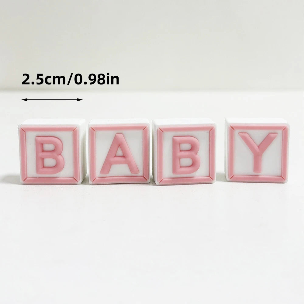 Pink acrylic letter cake toppers spelling BABY in white and pink colors