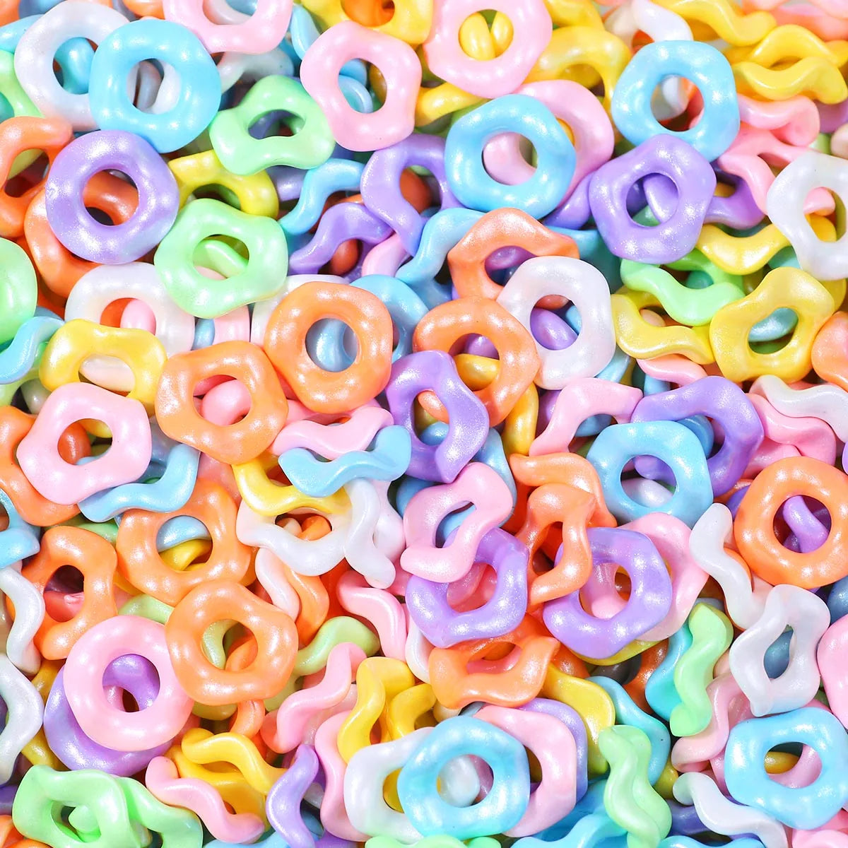 A close-up of colorful, wave-patterned acrylic beads in various pastel shades like pink, yellow, blue, and purple.