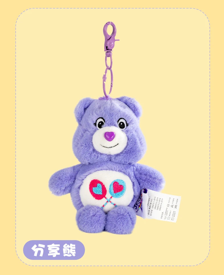 A purple Care Bears plush toy keychain with a pink charm attached, displayed against a light yellow background.