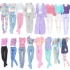 A collection of various fashion doll outfits featuring tops and pants in pastel and bright colors.