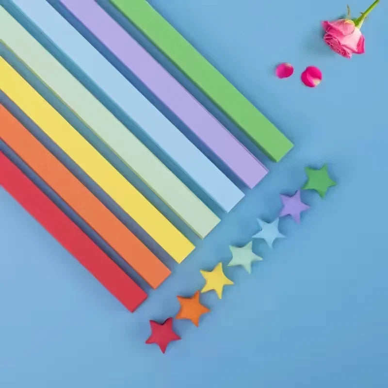 A collection of colorful origami star strips in various shades arranged diagonally on a light blue background.