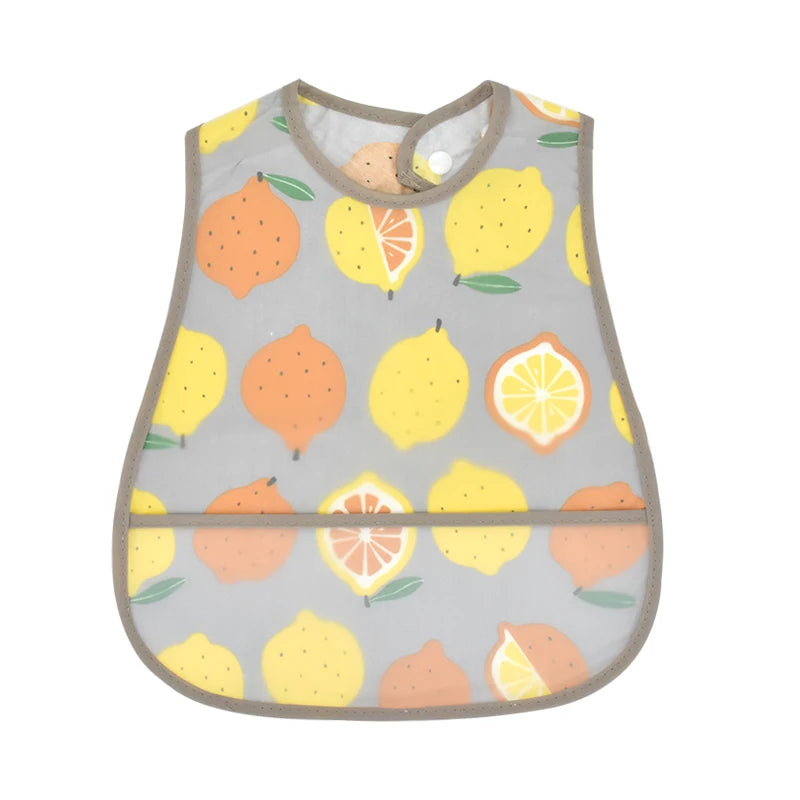 A light gray baby bib with a cartoon pattern of sliced oranges and lemons.