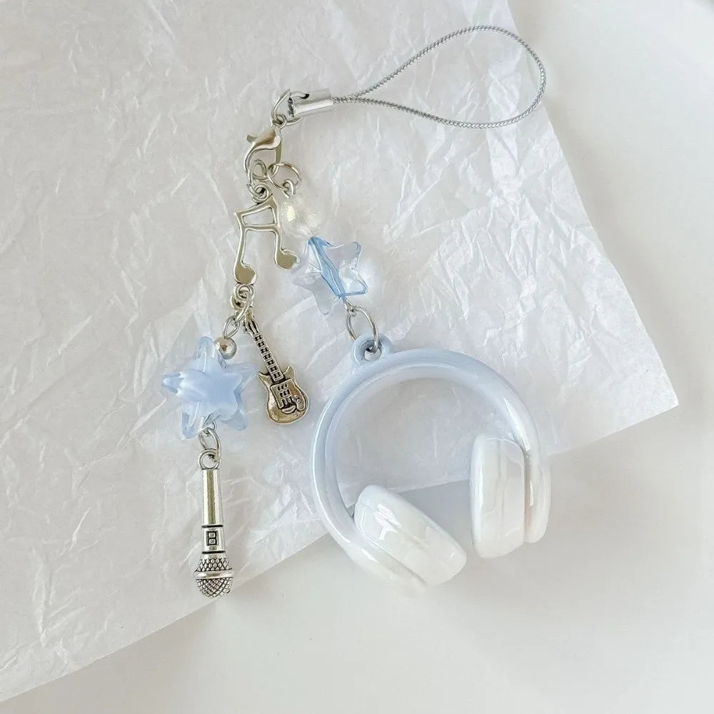 Silver beaded wing cross phone lanyard keychain with a light blue charm resting on white paper.