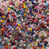 A close-up view of a colorful mix of faceted crystal rondelle glass beads for jewelry making