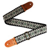 An embroidered guitar strap featuring a geometric pattern on black fabric with brown leather ends.