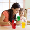 A woman is showing a child how to use a mini recycling truck toy set.