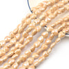 A close-up of multiple strands of light beige and white heart-shaped acrylic beads for jewelry making.