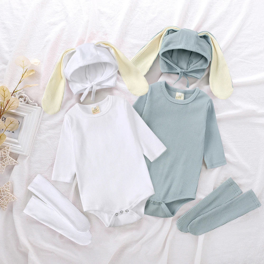 A set of white and light blue rabbit themed clothing for babies, including a romper, hat, and socks.