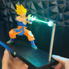 A figurine of Son Goku performing a Kamehameha attack with a glowing green light, displayed on a black base.