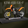 A black and orange 1:18 scale diecast model of a KTM 450 SX-F motorcycle on a display stand.