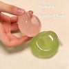 A hand holds a pink silicone squishy stress ball and a green one, demonstrating its portable and easy-to-clean features.