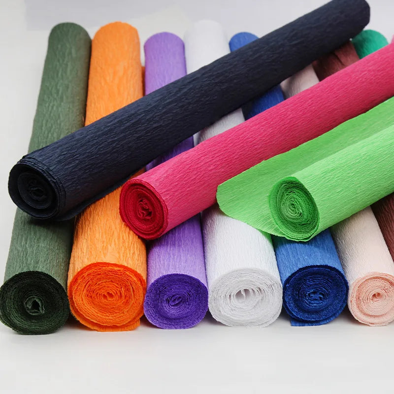 A collection of colorful crepe paper rolls in various shades including green, orange, purple, and pink.