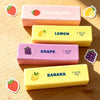 Five squishy fidget toys in pink, yellow, and purple colors featuring strawberry, lemon, grape, and banana designs.