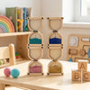 A wooden Montessori busy board for toddlers featuring gears, switches, and sensory elements.