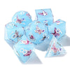 A set of seven light blue polyhedral dice featuring pink floral butterfly designs for tabletop role-playing games