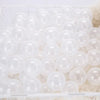 A white plastic basket filled with a large quantity of clear, round, inflated play balls.