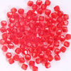 A pile of small, faceted, translucent red crystal glass beads for jewelry making.