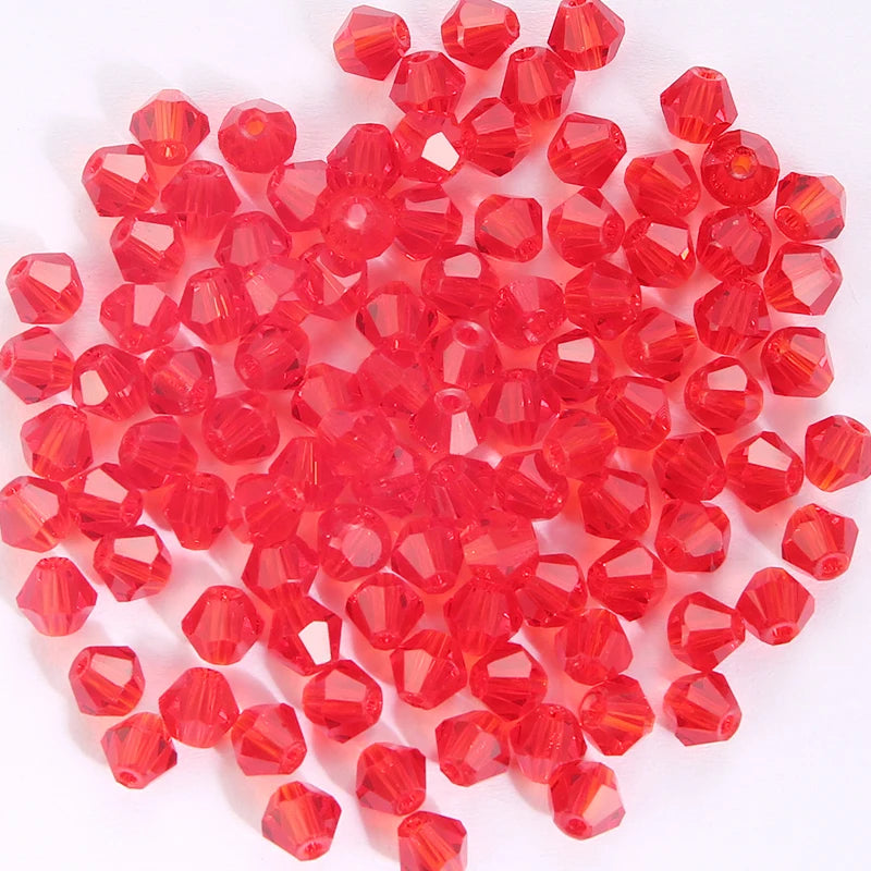 A pile of small, faceted, translucent red crystal glass beads for jewelry making.