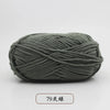 A ball of dark gray pre-dyed milk cotton yarn, 79 strands thick, shown lying on a white surface.