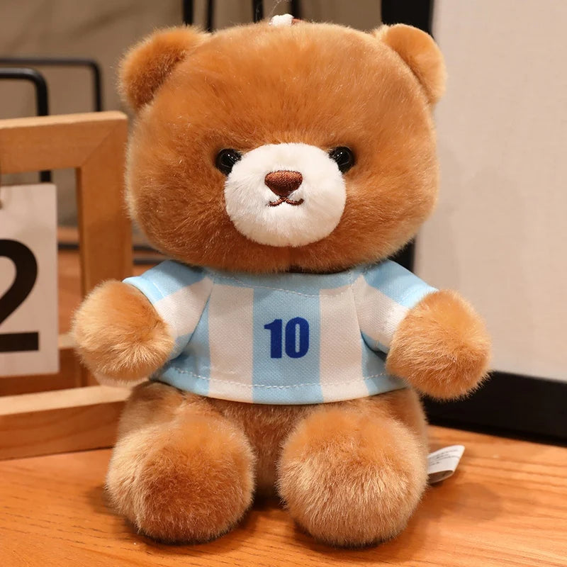 A fluffy brown teddy bear wearing a light blue and white striped football jersey with the number 10