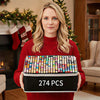 A woman holds a black box of 274 alcohol markers with vibrant colors in front of a fireplace decorated for the holidays.