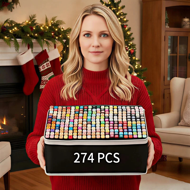 A woman holds a black box of 274 alcohol markers with vibrant colors in front of a fireplace decorated for the holidays.